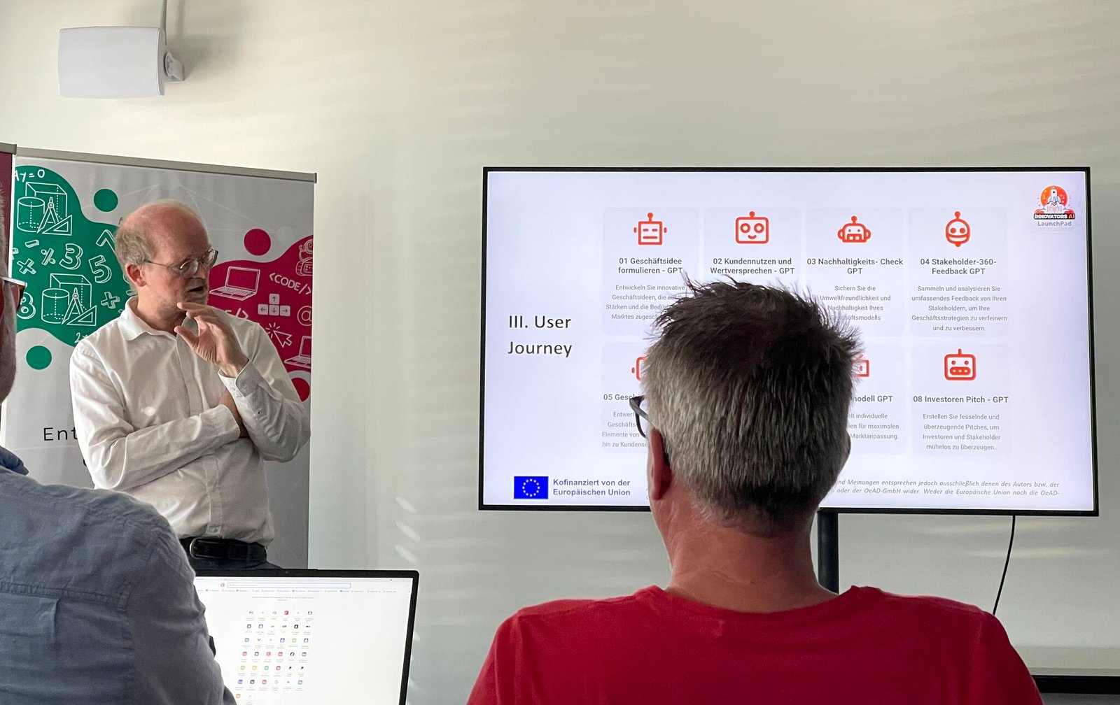 Paul Schober diskutiert im KI-Workshop mit Teilnehmenden vor einer dargestellten User Journey